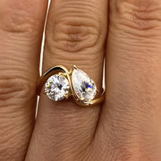 Pear and round cut Moissanite Toi et Moi engagement ring in 14K yellow gold with curved band