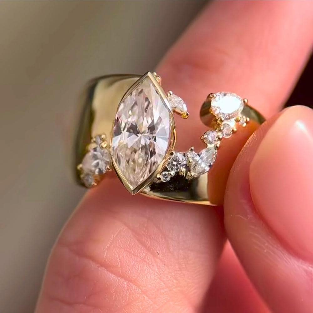 14K yellow gold fractured cigar band ring with marquise cut moissanite diamonds and round cut accents